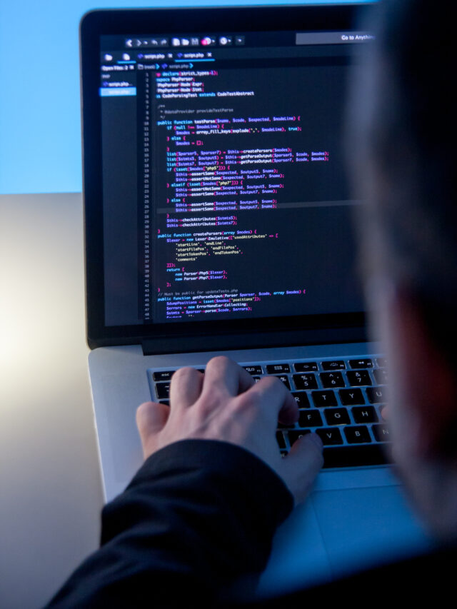 Web Coder working on laptop computer in office